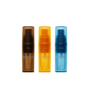 Three 'breeze' oral care products in brown, orange, and blue on a transparent background